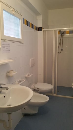 A bathroom with two toilets, a sink, and a shower. - Canasta (Riccione)