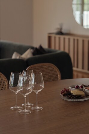 A dining table with three wine glasses and a fruit platter.