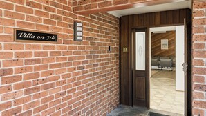 A brick wall with a sign reading 'Villa on 7th' and a door leading to an interior space.