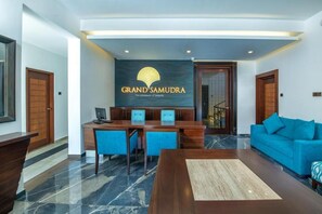 Un área de recepción con un mostrador, sillas y un sofá.