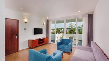 Una sala de estar moderna con un televisor de pantalla plana, un mueble de madera, un sofá y un sillón azul.