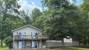 A two-story house with a balcony, a fenced yard, and a fire pit. - Sage Lake Paradise (Hale)