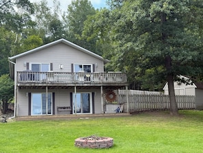 A two-story house with a balcony, a covered patio, and a fire pit in the yard. - Sage Lake Paradise (Hale)