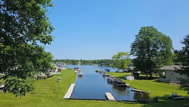 A marina with boats docked, a grassy area, and a clear sky. - Sage Lake Paradise (Hale)
