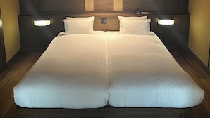 Un lit double avec une tête de lit, deux lampes de chevet et un plancher en bois.