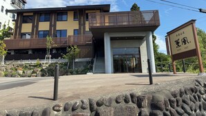 Un bâtiment moderne doté d’un toit plat, d’un balcon et d’une enseigne avec des caractères étrangers.