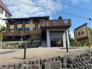 Un bâtiment moderne doté d’un toit plat, d’un balcon et d’une enseigne avec des caractères étrangers.