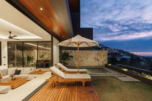 Ein moderner Außenbereich mit Pool, Liegestühlen und einer Holzterrasse.
