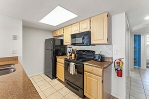 A modern kitchen with a refrigerator, microwave, stove, and toaster. - 3BR Kissimmee Home Near Disney Springs (Kissimmee)