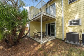 A yellow house with a covered patio, a balcony, and an air conditioning unit. - 3BR Kissimmee Home Near Disney Springs (Kissimmee)