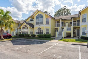 A yellow building with a large arched window and a balcony. - 3BR Kissimmee Home Near Disney Springs (Kissimmee)