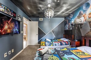 A bedroom with a Star Wars-themed ceiling, a bed with a colorful Star Wars blanket, and a Star Wars poster on the wall. - 3BR Kissimmee Home Near Disney Springs (Kissimmee)