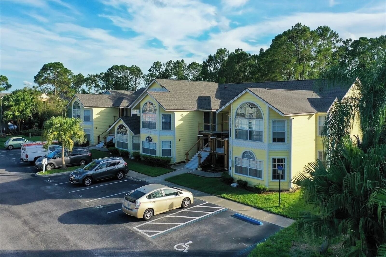 A two-story building with a parking lot in front.