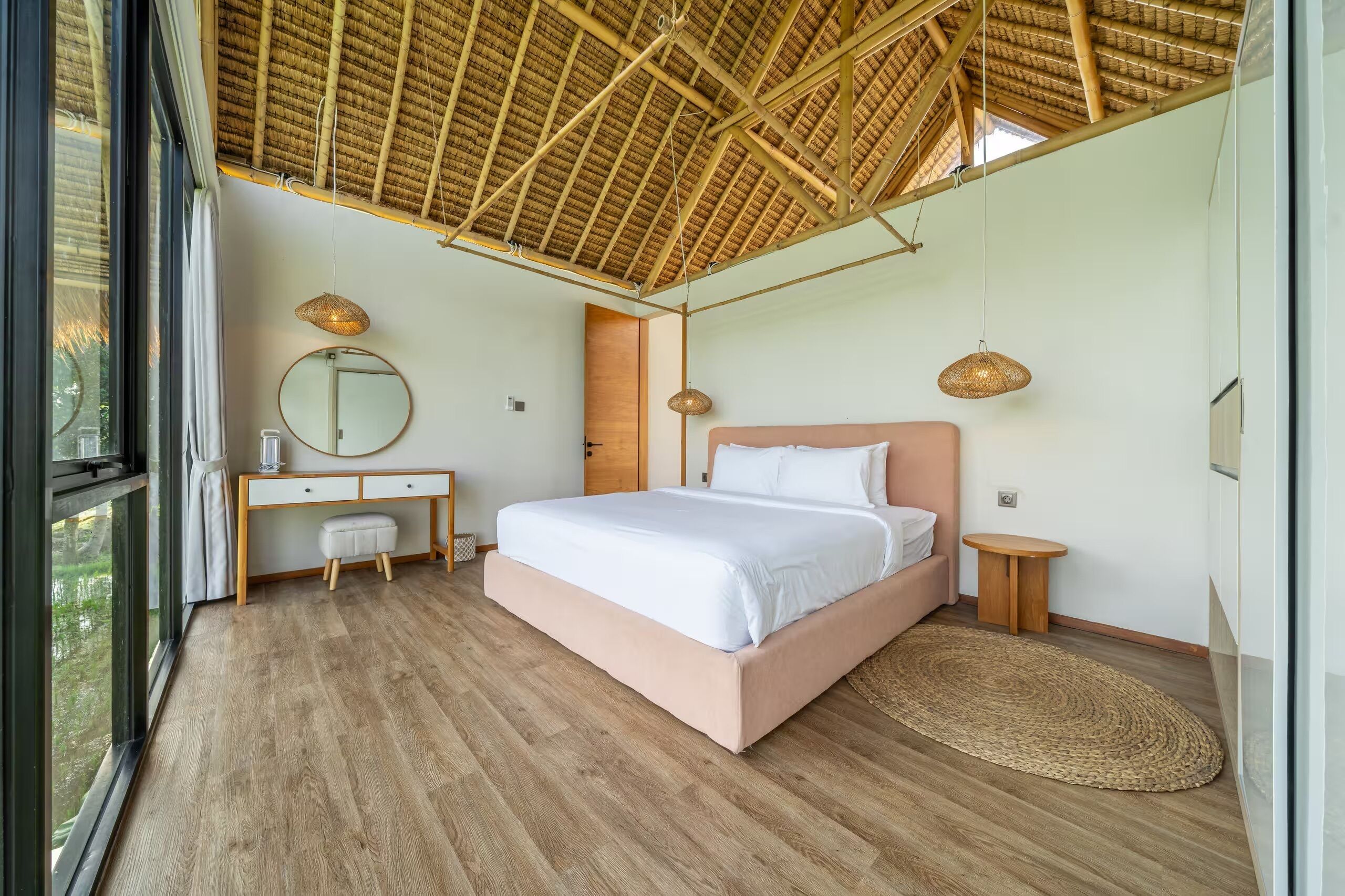 Un dormitorio con cama, mesitas de noche, un espejo y una ventana.