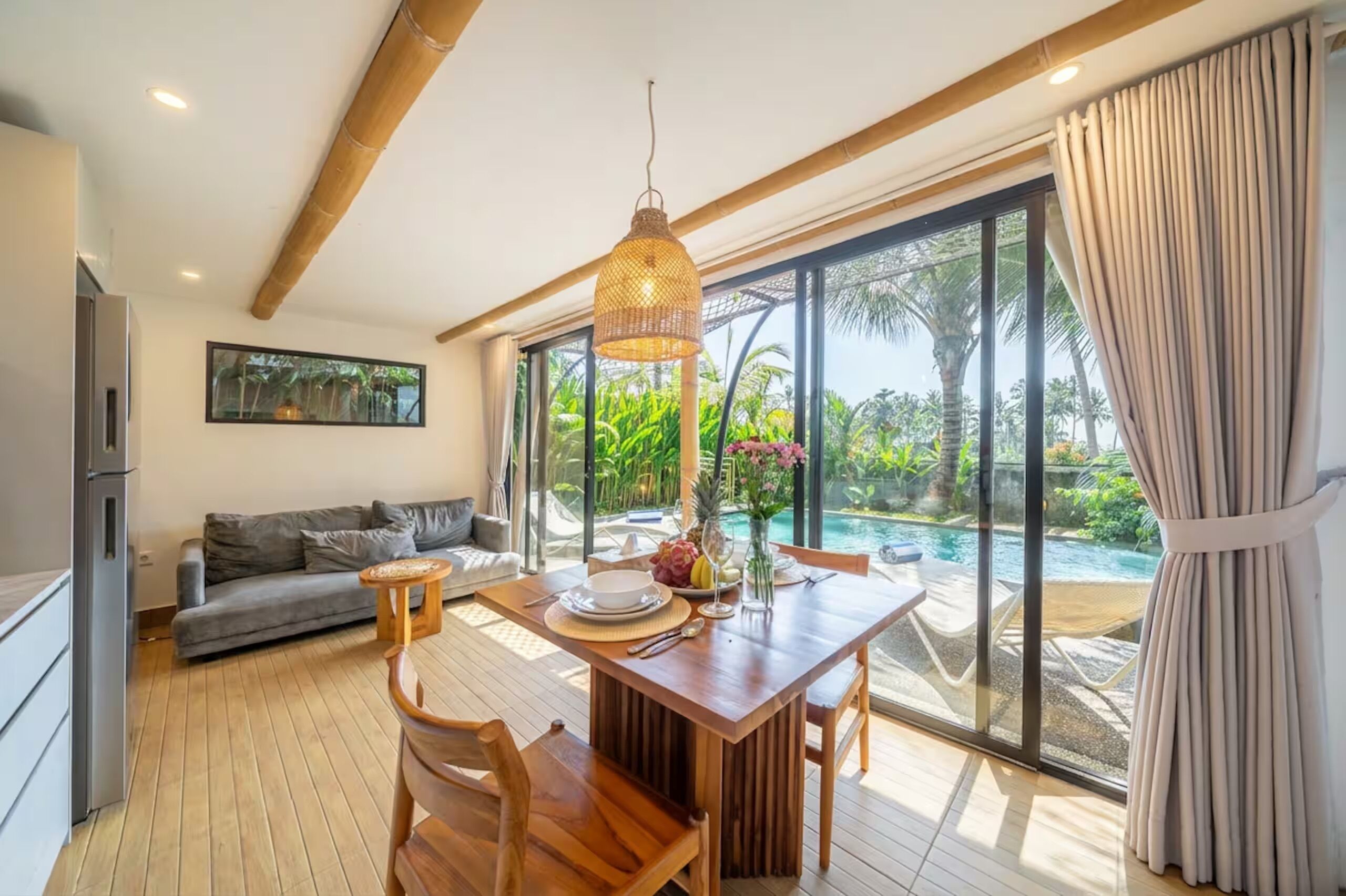 Una cocina moderna con comedor, ventanas amplias y vista a una piscina.