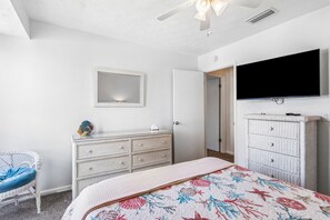 A bedroom with a bed, dresser, chair, and a TV. - 3BR Condo - Near Main Beach - Community Pool (Fernandina Beach)