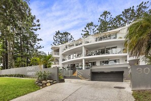 A multi-story building with balconies, a garage, and a sign indicating 'Picture Point Apartments.' - Picture Point Penthouse 12 - Renovated Coastal Retreat with Sunset Views (Noosa)