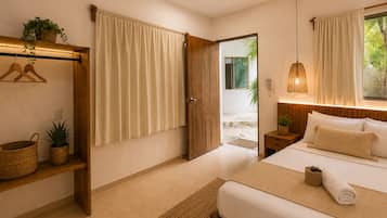 Quarto com cama, mesa de cabeceira, luminária pendente, porta de madeira e vista para o exterior.