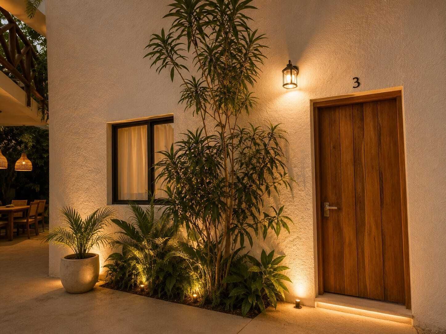 Un edificio con puerta de madera, ventana con cortina y planta en maceta.