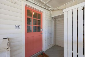 A red door with a glass panel, a white door, and a white gate. - Silver Sand Dollar | Upscale 6BR Escape-Hot Tub (North Myrtle Beach)