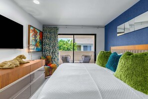 A modern bedroom with a large bed, a flat-screen TV, a wooden dresser, and a view of the outdoors. - Casa del Segundo | MCM 1BR | 2 Pools & Tennis | Palm Springs (Palm Springs)