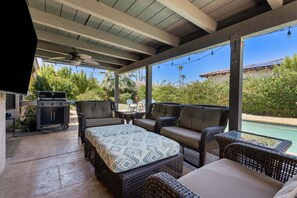 An outdoor patio with wicker furniture, a grill, and a view of a swimming pool. - Boqueron and Beyond | Private Pool & Spa | Entertainer's Backyard | 3BR | Bermuda Dunes (Bermuda Dunes)