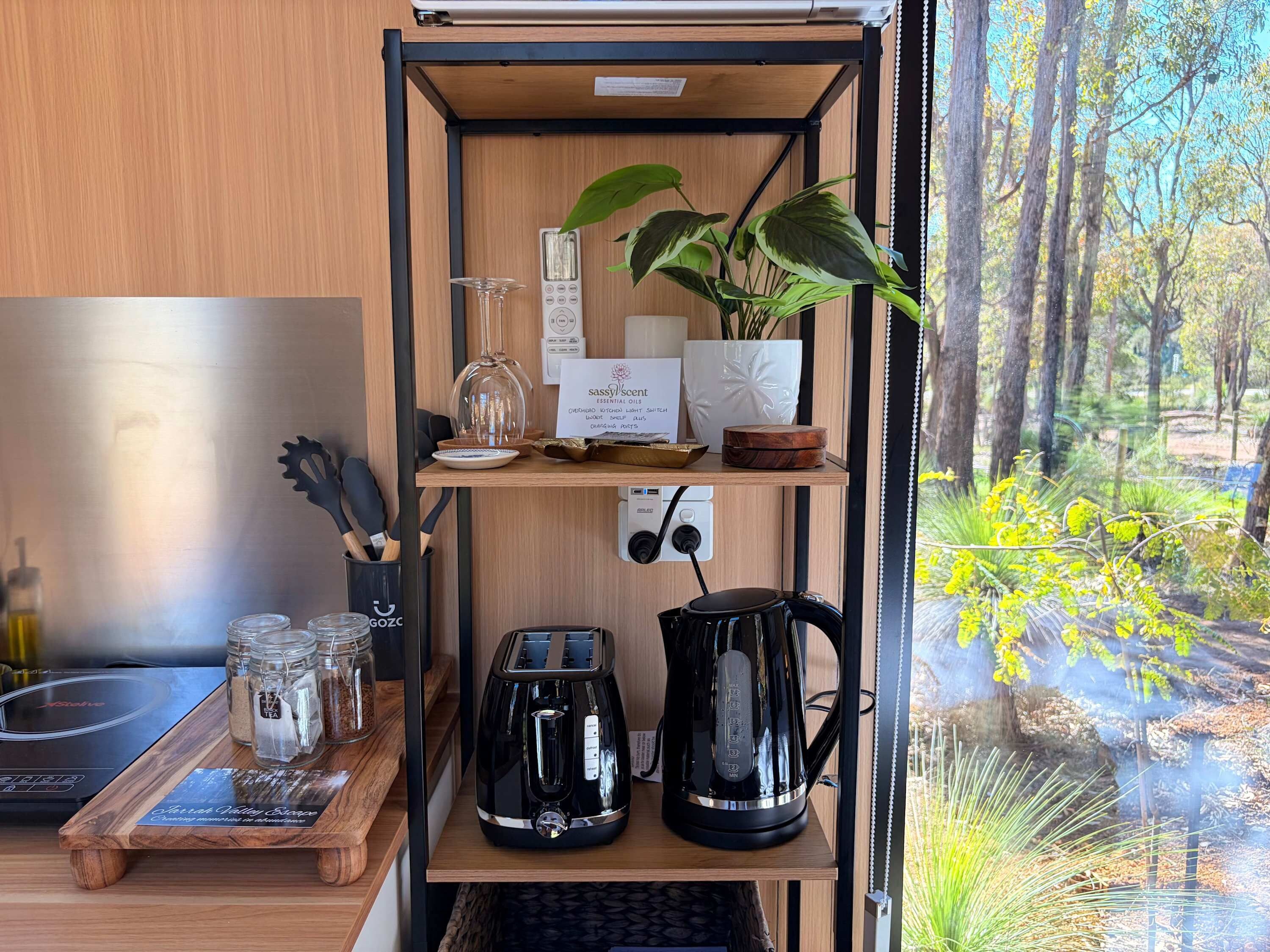 Eine Küchenzeile mit Kaffeemaschine, Toaster und Gläsern auf einem Holzboden.