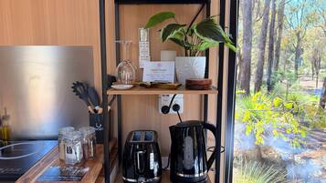 Eine Küchenzeile mit Kaffeemaschine, Toaster und Gläsern auf einem Holzboden.
