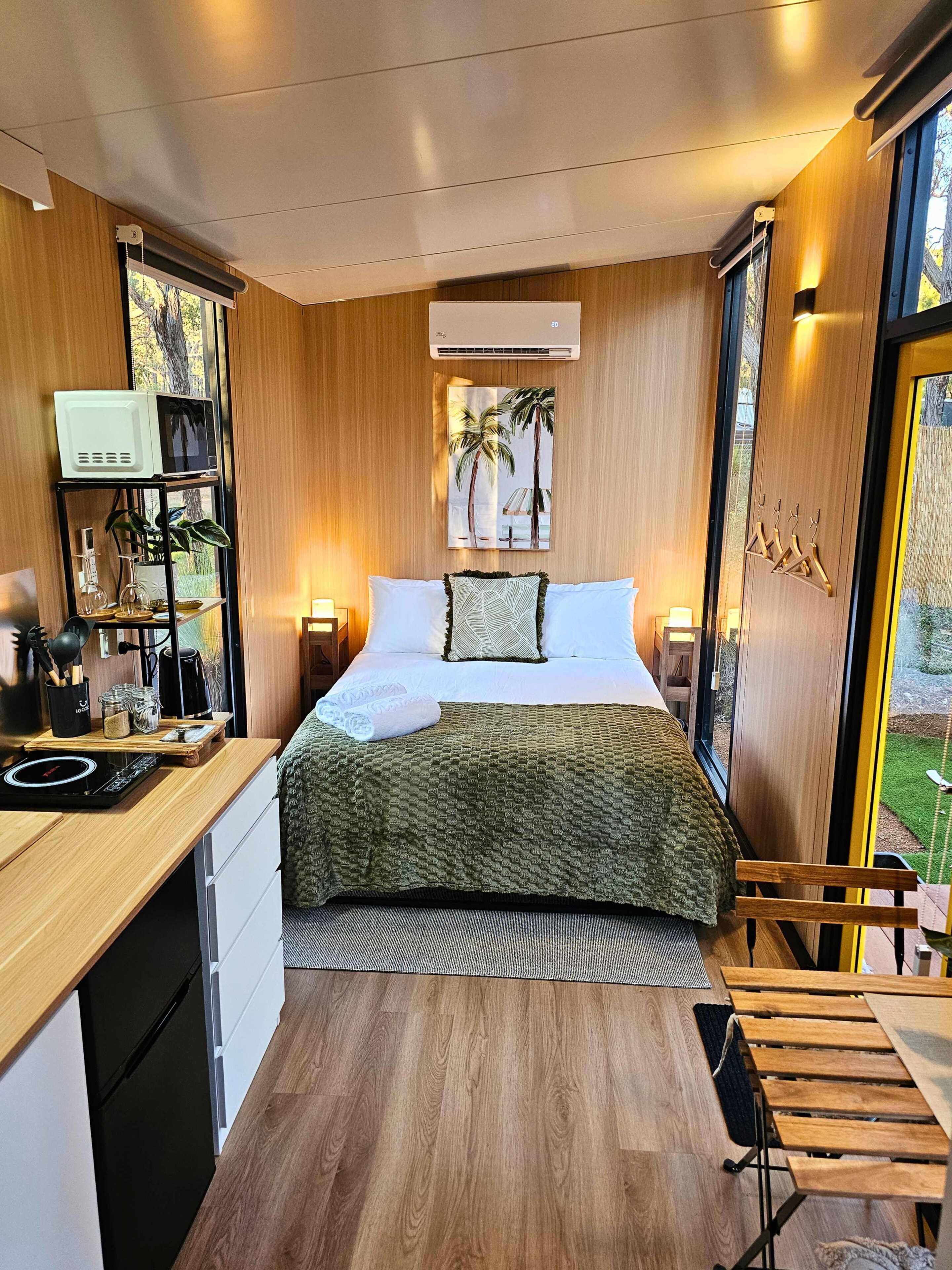 Een moderne slaapkamer met een bed, nachtkastjes, een bureau en een raam.