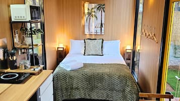 Een moderne slaapkamer met een bed, nachtkastjes, een bureau en een raam.