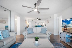 Ein Wohnzimmer mit einer Couch, einem Couchtisch und Deckenventilatoren.