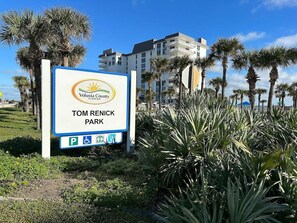 Schild für den Tom Renick Park im Volusia County, Florida, mit Parkplatzsymbol und Barrierefreiheitszeichen.