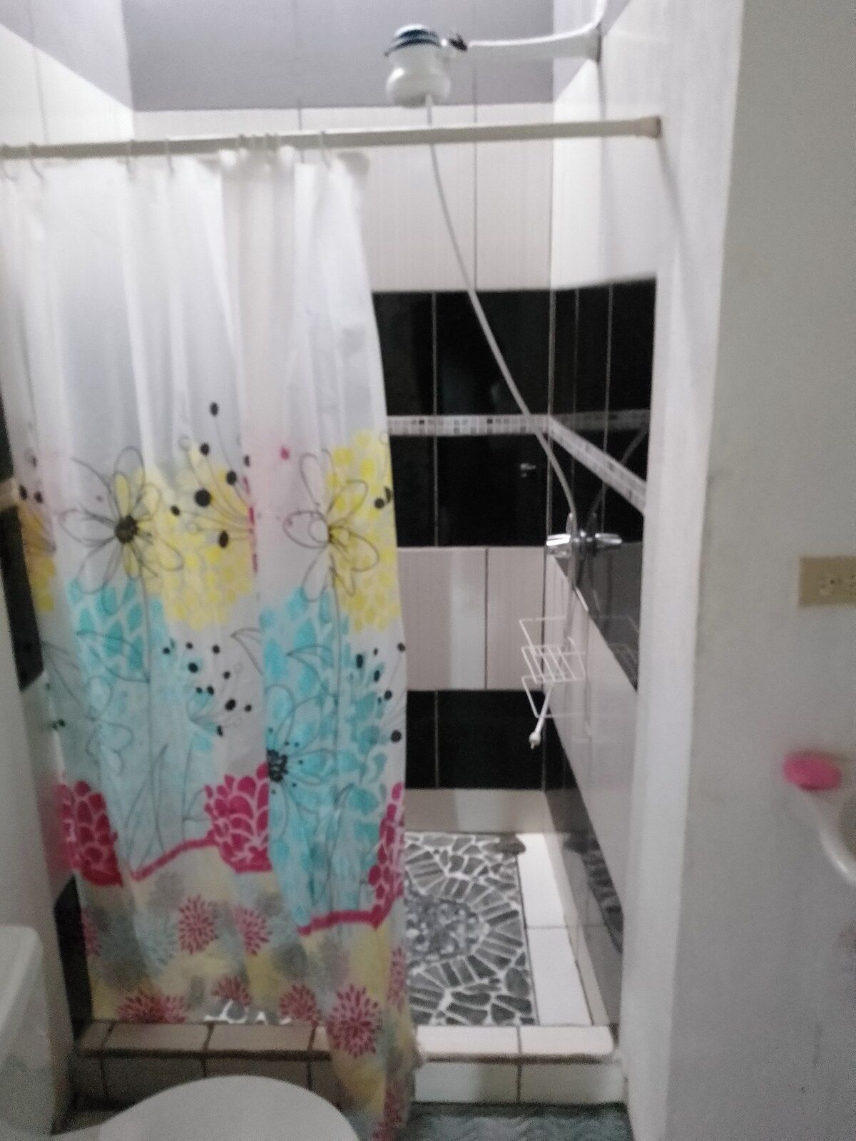 A bathroom with a shower, a toilet, and a sink.
