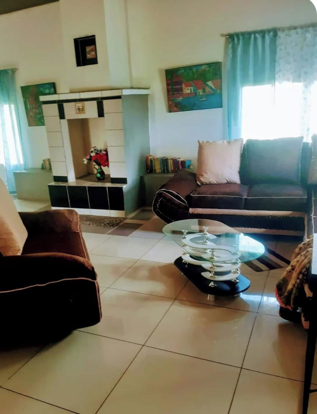 Un salon avec un canapé, un fauteuil et une table basse en verre.