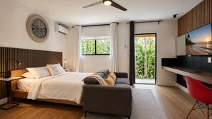 Quarto moderno com cama, mesa de cabeceira e uma cadeira vermelha.
