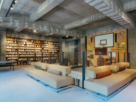 Una biblioteca con estanterías, un aro de baloncesto y dos sofás.