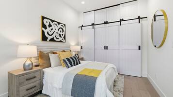 A bedroom with a bed, nightstands, a large mirror, and a wardrobe with sliding doors.