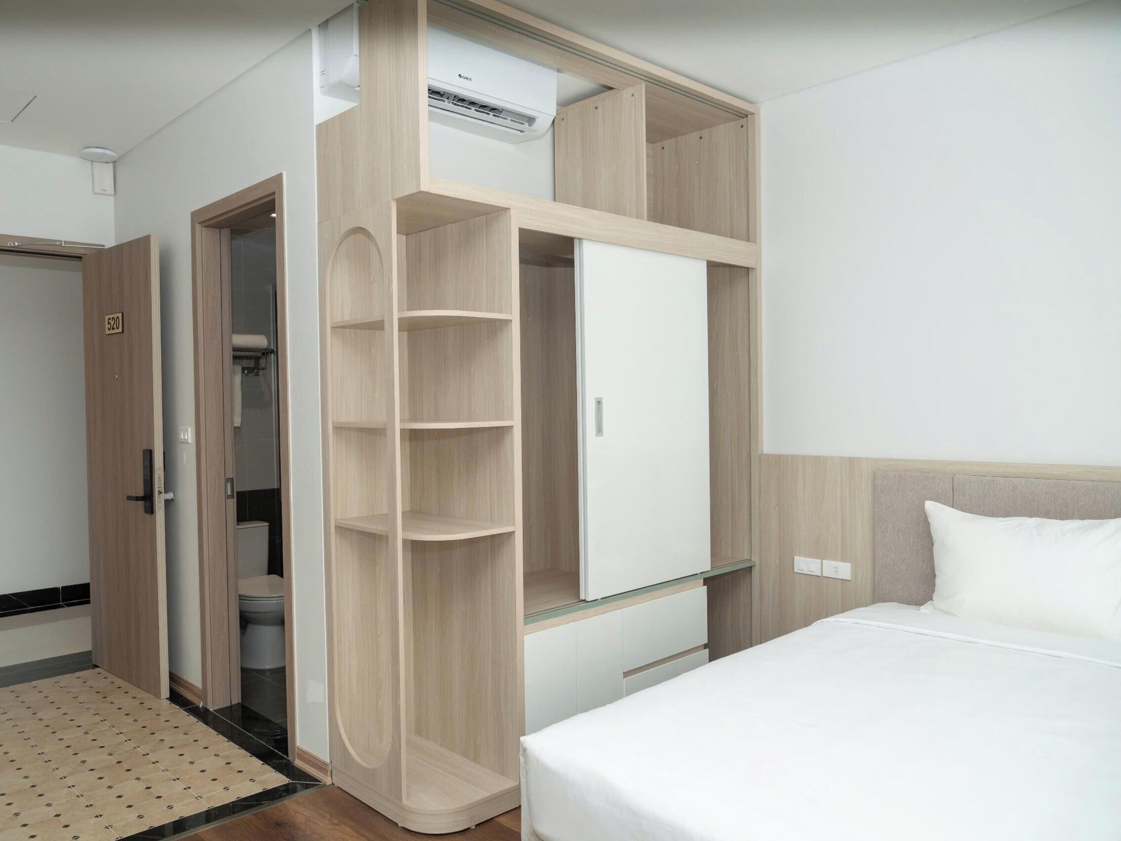 A hotel room with a bed, a wardrobe, and a bathroom.