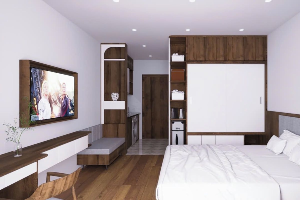 A modern bedroom with a large bed, a TV mounted on the wall, and built-in shelving.