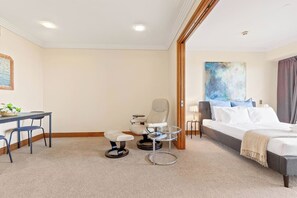 Ein Hotelzimmer mit einem Bett, einem Schreibtisch, einem Stuhl und einem kleinen Tisch.