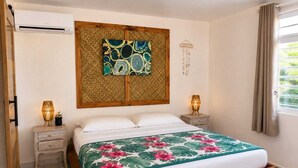 Una camera da letto con un letto di legno, una testiera decorativa, lampade da comodino e una finestra con tende.