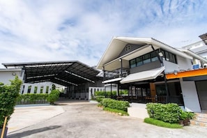 A modern building with a covered entrance, a balcony, and a parking area. - S3 Hotel Rayong (Rayong)