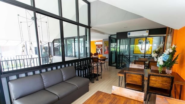Un interior moderno con un sofá, mesa de comedor, sillas y obras de arte.