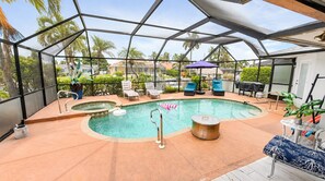 Una piscina exterior techada con sillas de descanso y un jacuzzi.