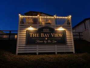A sign for 'The Bay View' with a view of the sea.