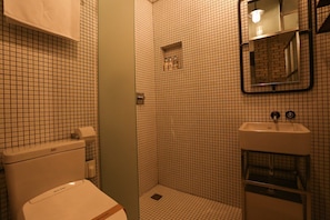 A bathroom with a toilet, a sink, and a shower area. - Jongro Boutique Hotel K (Seoul)