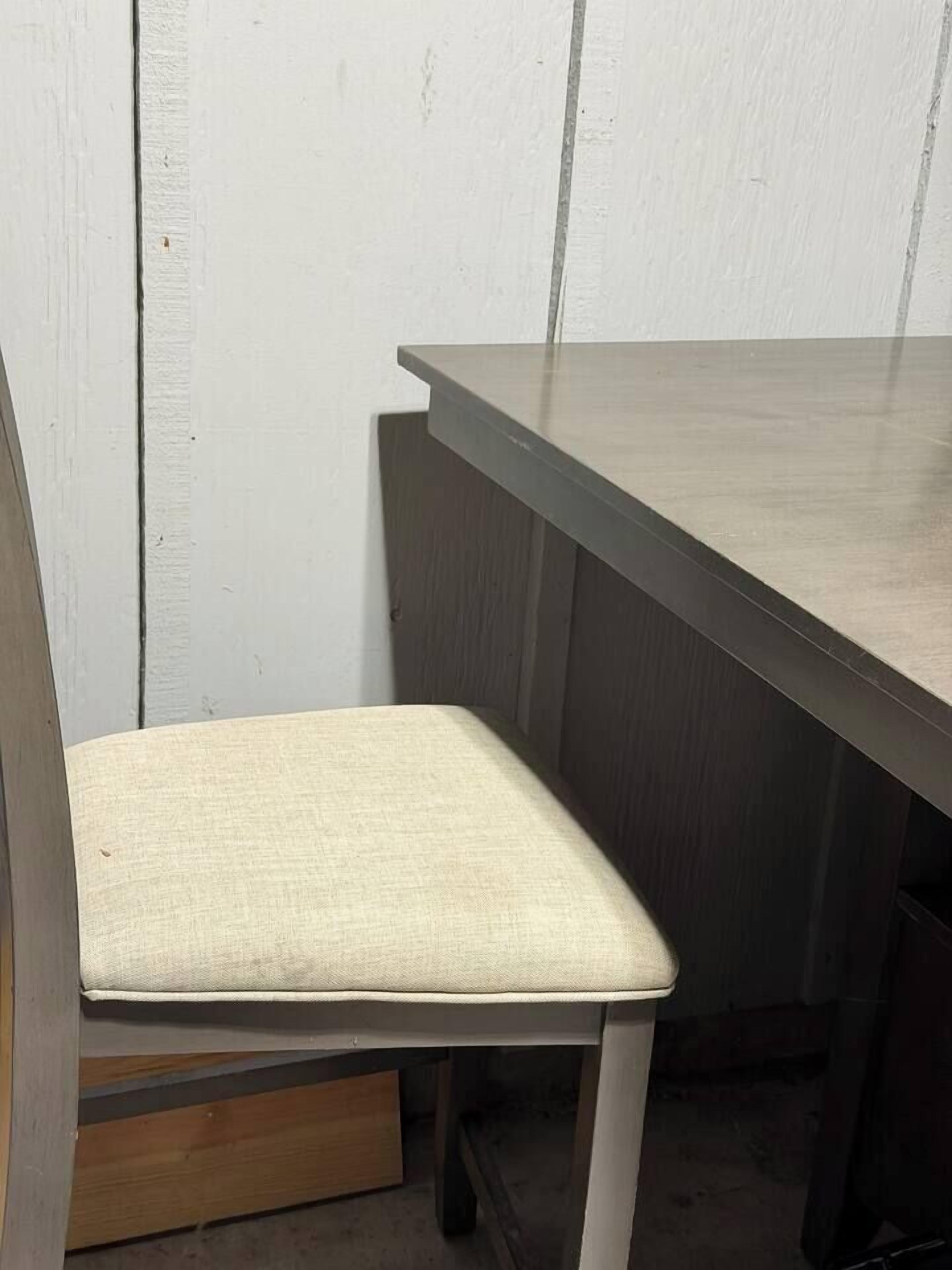 Un coin de pièce avec une chaise en bois et une table de couleur sombre.