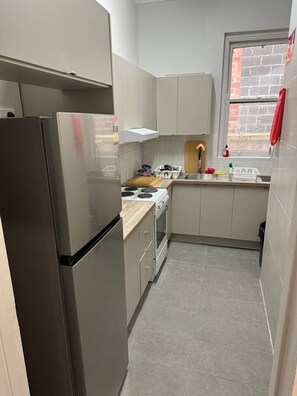 A compact kitchen with a refrigerator, stove, and sink. - 5 mins to Central Sydney
Lord Raglan Hotel (Alexandria)