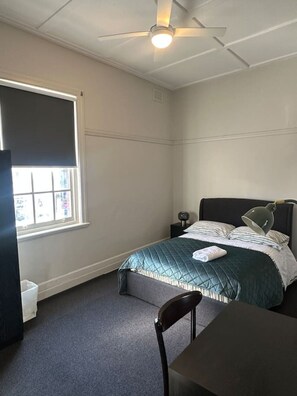 A bedroom with a bed, a desk, a chair, a window with blinds, and a ceiling fan. - 5 Mins to Central Sydney
Lord Raglan Hotel (Alexandria)