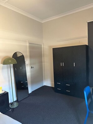 A room with a wardrobe, a mirror, a lamp, and a chair. - 5 minutes to Central Sydney - Lord Raglan Hotel (Alexandria)